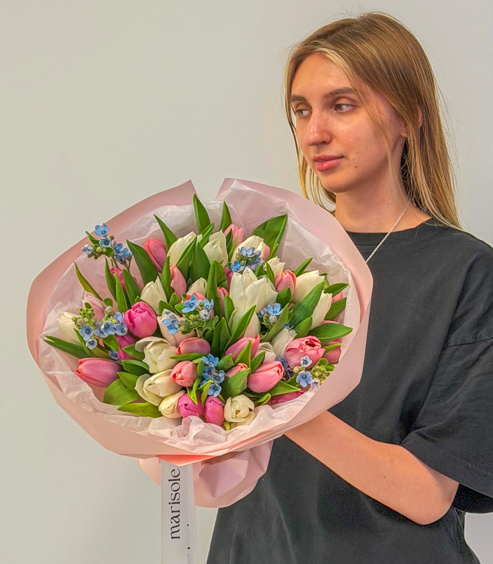 Person holding a bouquet of flowers with a plain background