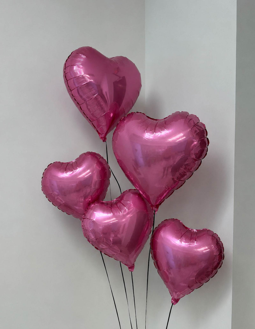 5 Pink heart-shaped balloons on a white background