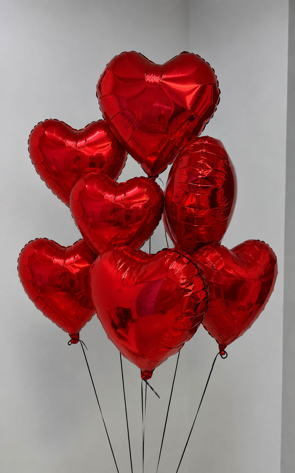7 Red heart-shaped balloons on a plain background