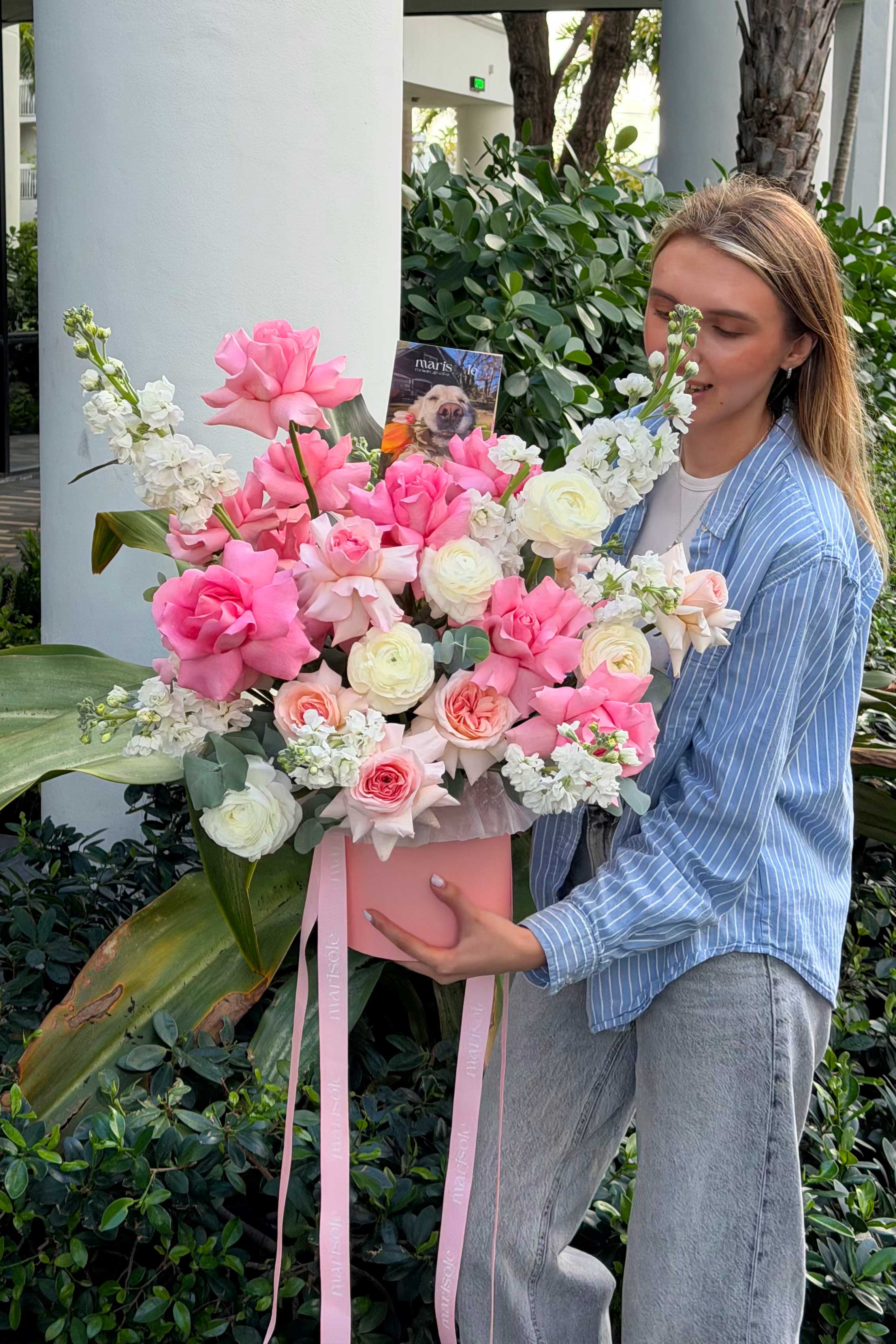 Person holding a large bouquet of flowers outdoors