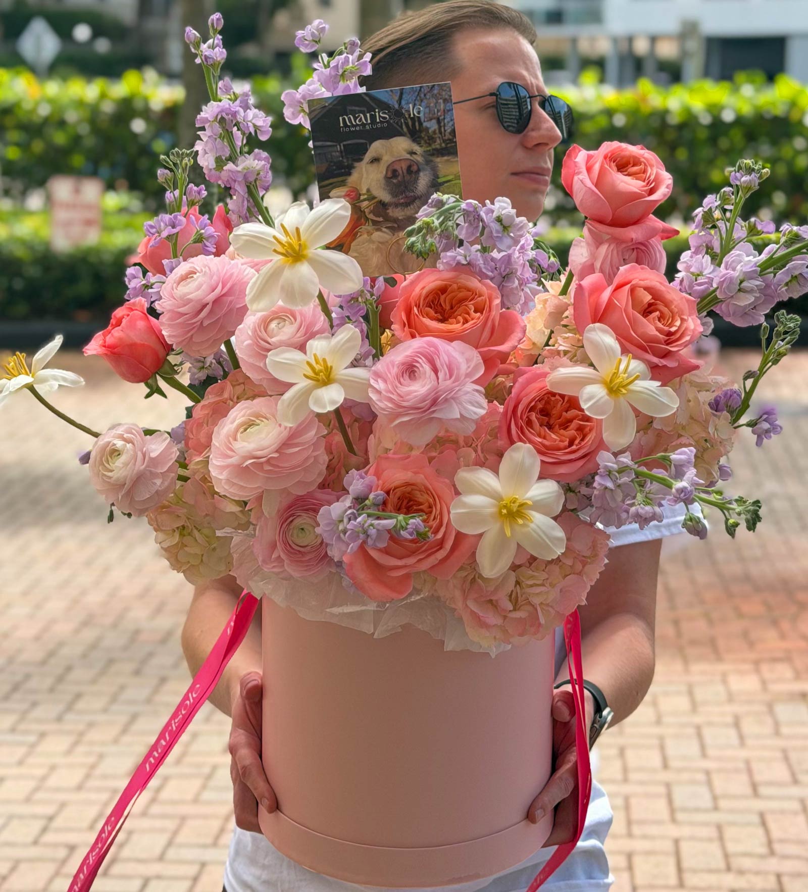 Pink flower box with ranunculus, garden roses, tulips, hydrangea, spray roses, and stock in soft pastel tones, featuring Marisole Flower Studio styling.
