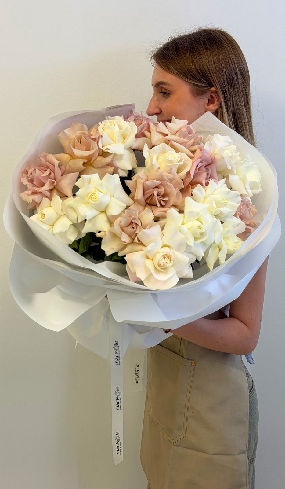 Person holding a bouquet of flowers against a plain background