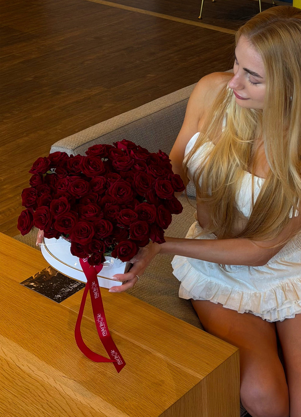 Woman holding a large bouquet of red roses in an indoor setting