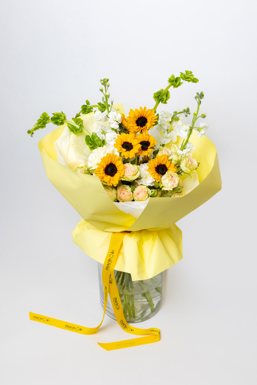 Bouquet of flowers with yellow ribbon on a light gray background