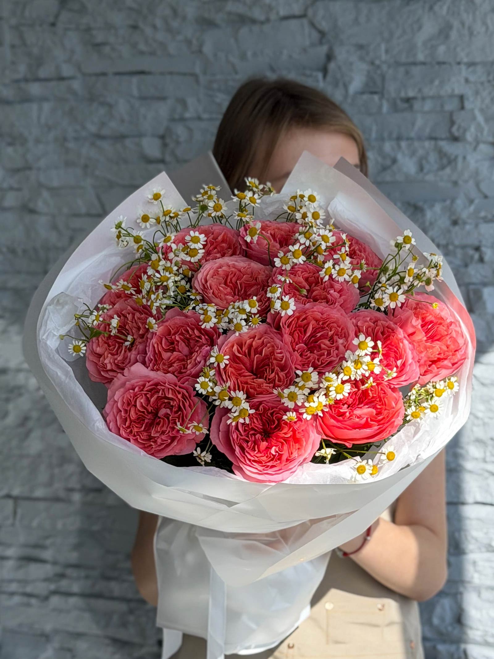 Garden Treasures bouquet with pink garden roses and chamomile wrapped in elegant white paper.