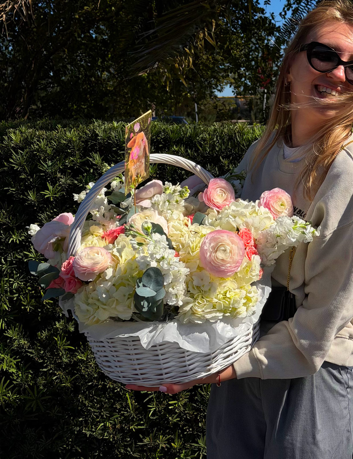 Person holding a flower basket outdoors