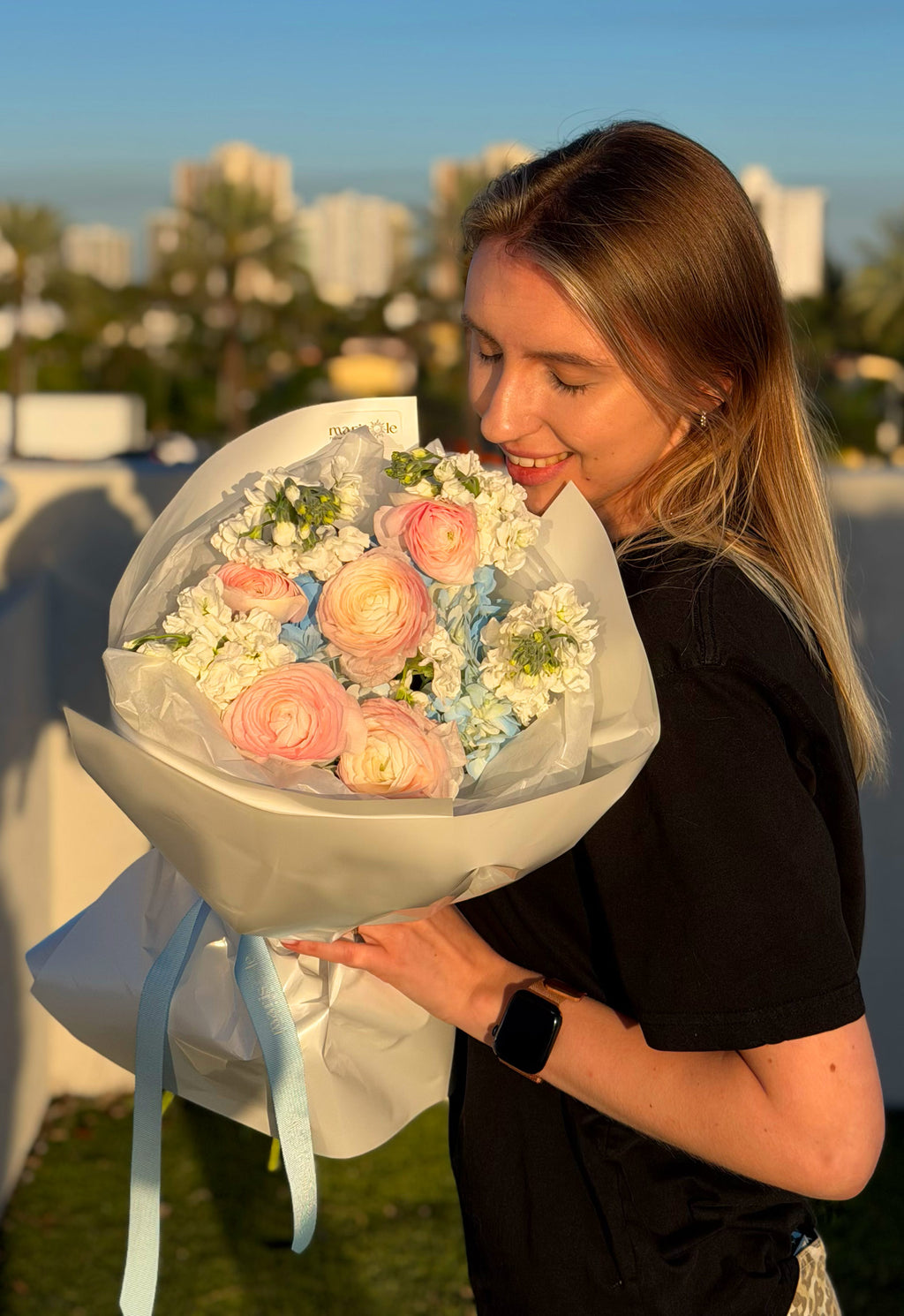 Woman holding a bouquet of flowers with a scenic background