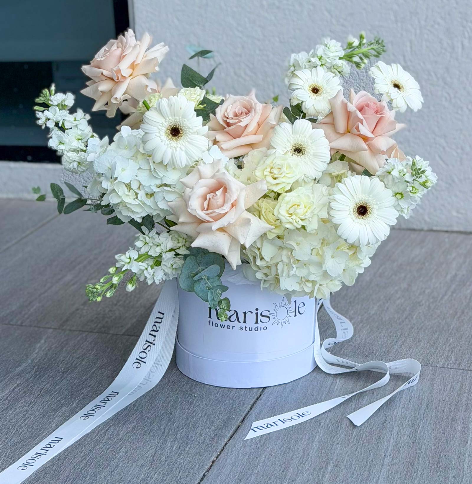 White and nude blush flower box with gerberas, hydrangeas, French roses, spray roses, and stock in a Marisole Flower Studio box.