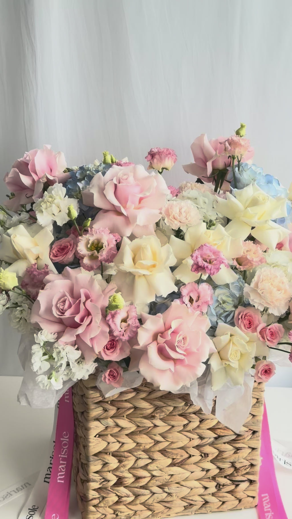 Video of the Love Letter Basket with pink, ivory, and blue flowers arranged in a woven basket.