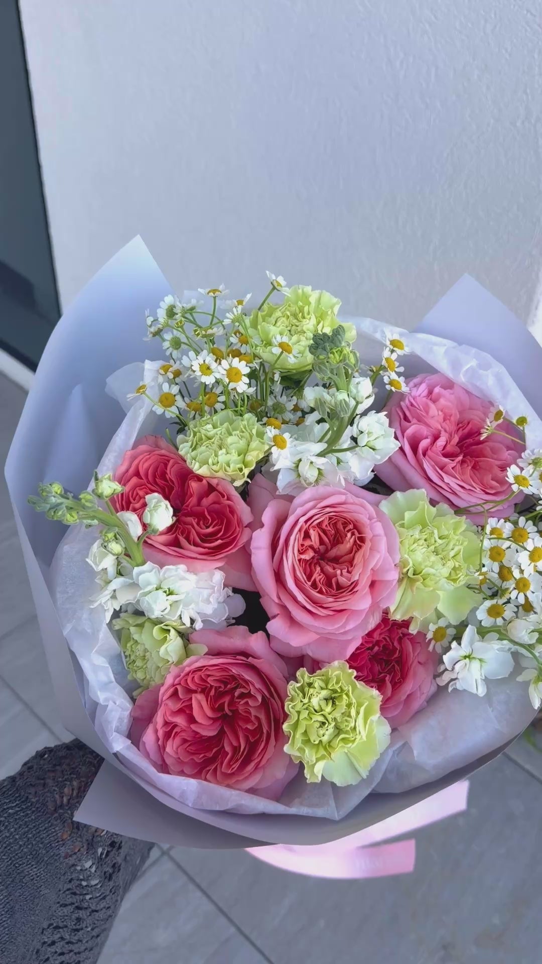 Cottage Blooms bouquet featuring pink garden roses, carnations, chamomile, and stock in white wrapping