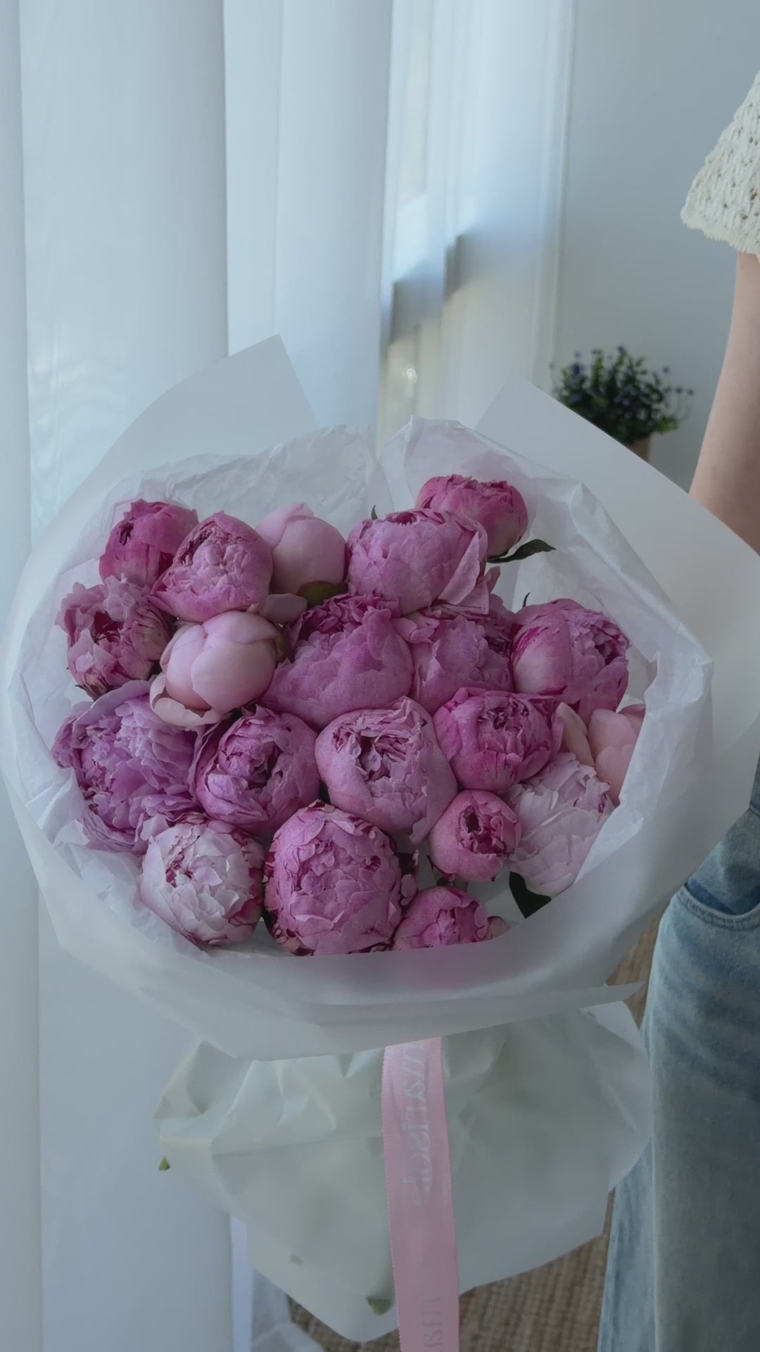 Video of a pink peonies bouquet wrapped in white paper with soft, romantic Marisole Flower Studio styling.