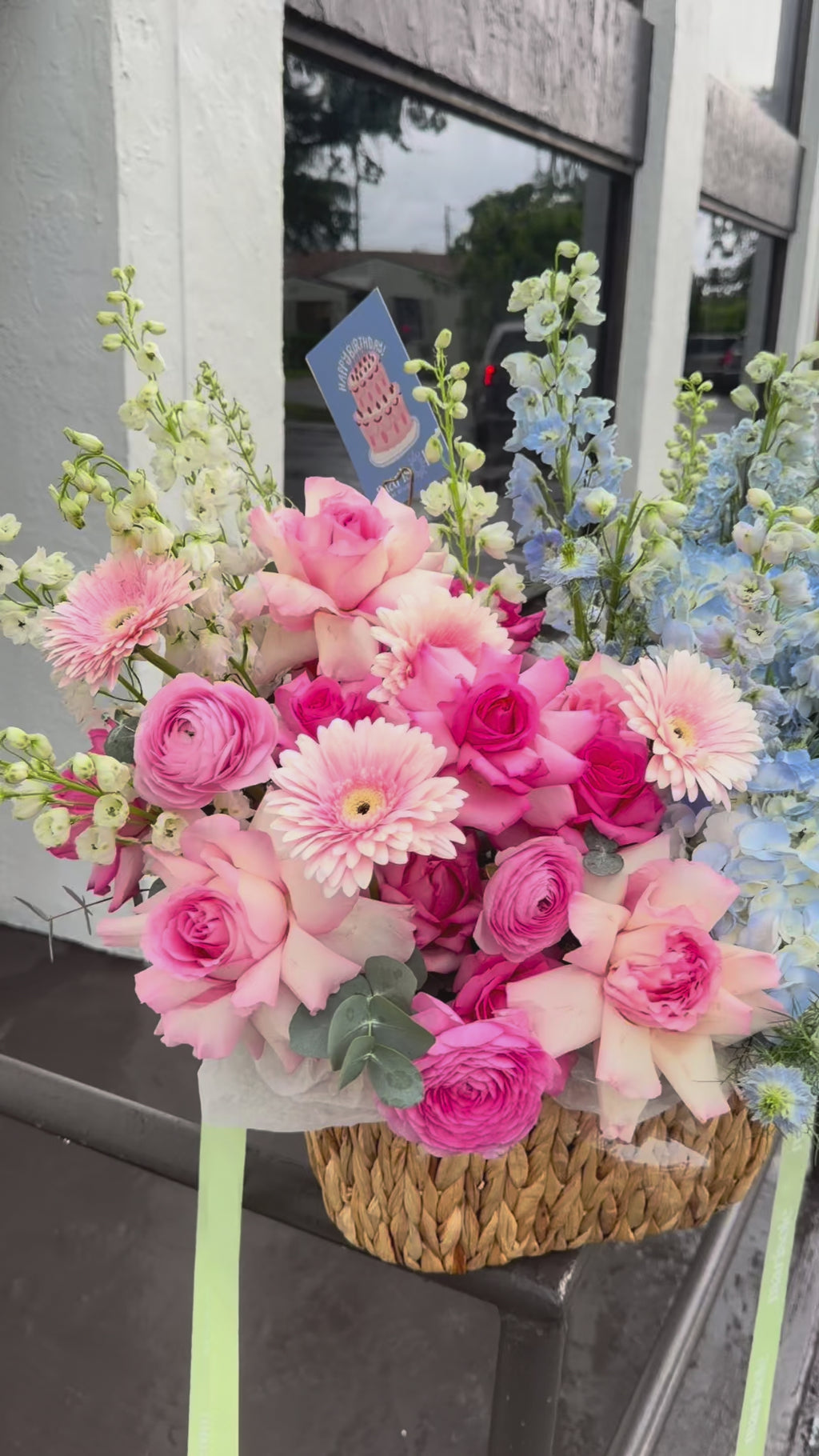 Video of the Glamorous Duo Basket with pink and blue flowers arranged in a woven basket.