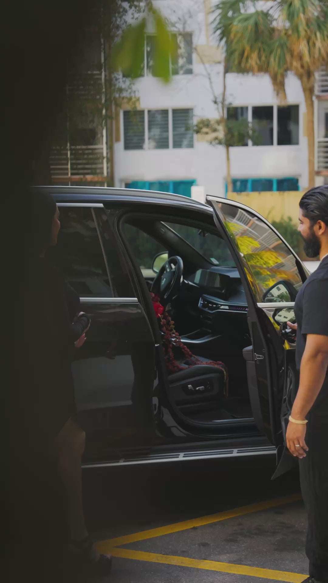 Video of a luxury flower delivery being placed in a car, featuring an elegant red and white flower arrangement.