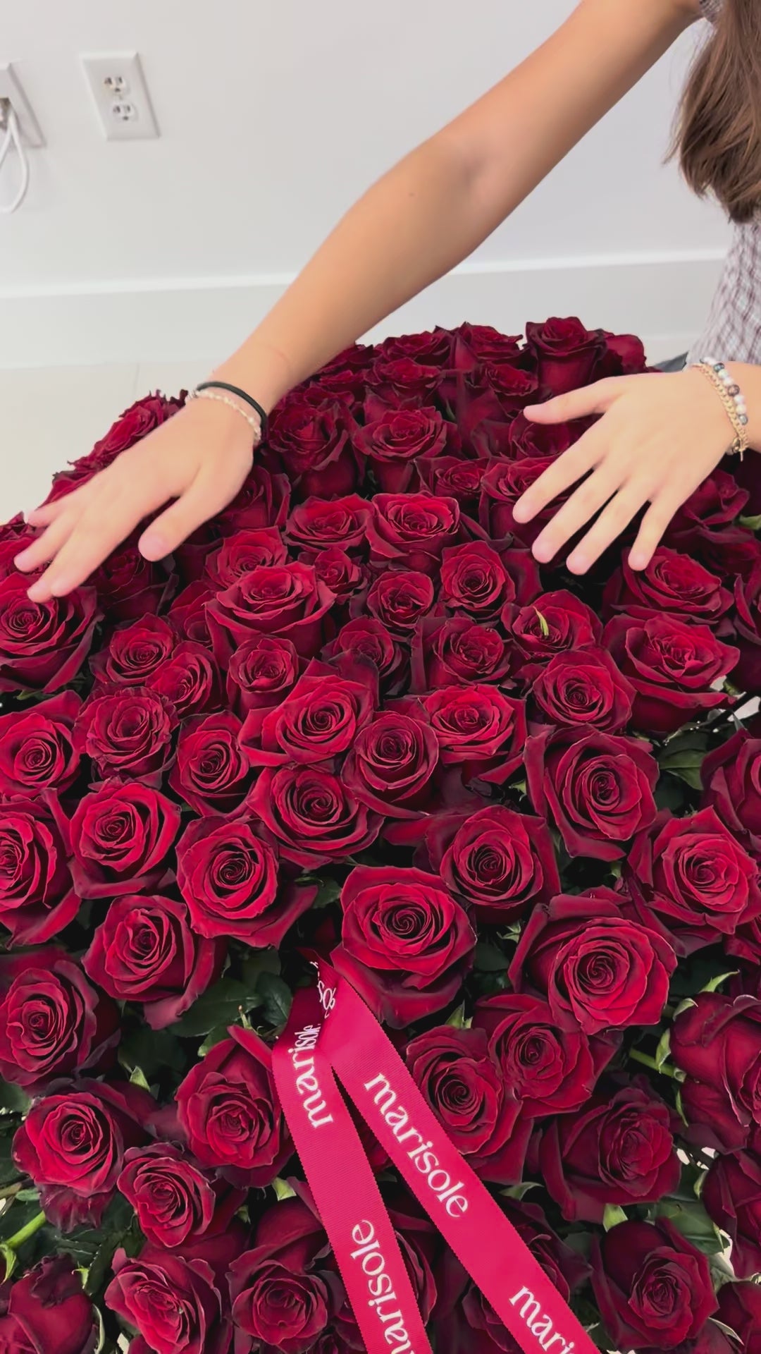 Video of a luxury basket filled with 200 red roses, styled with Marisole Flower Studio ribbons for a romantic statement gift.