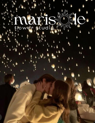 Greeting card with a couple under glowing lanterns at night, featuring Marisole Flower Studio logo.