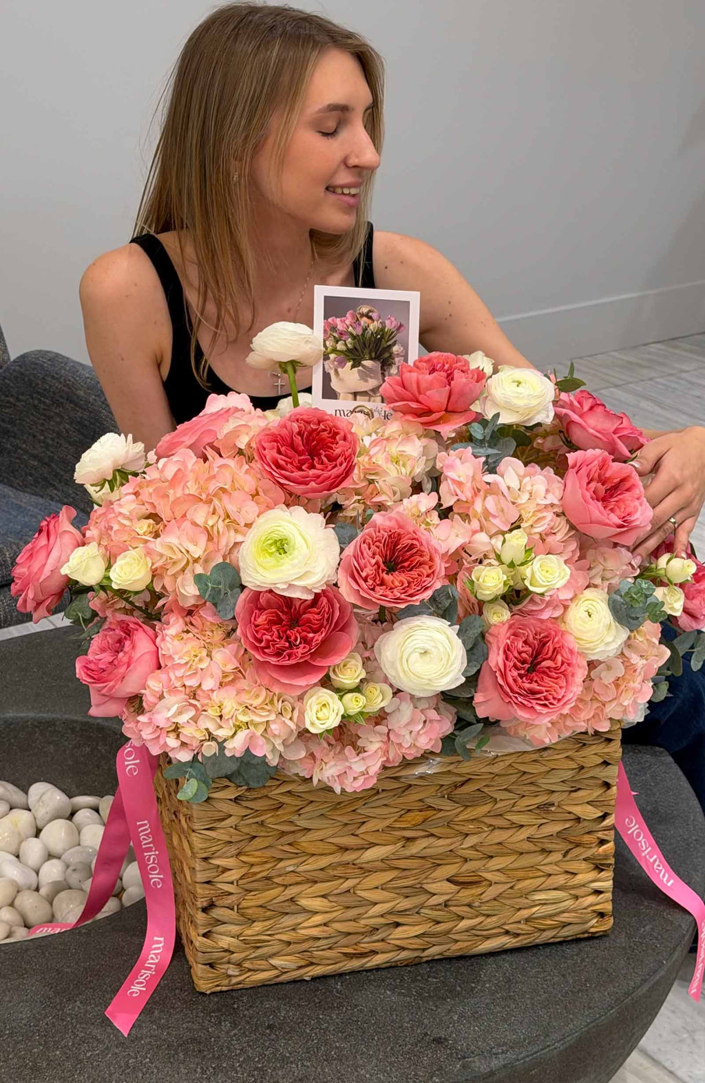 Large woven flower basket with blush pink garden roses, delicate spray roses, hydrangeas, and creamy white ranunculus.