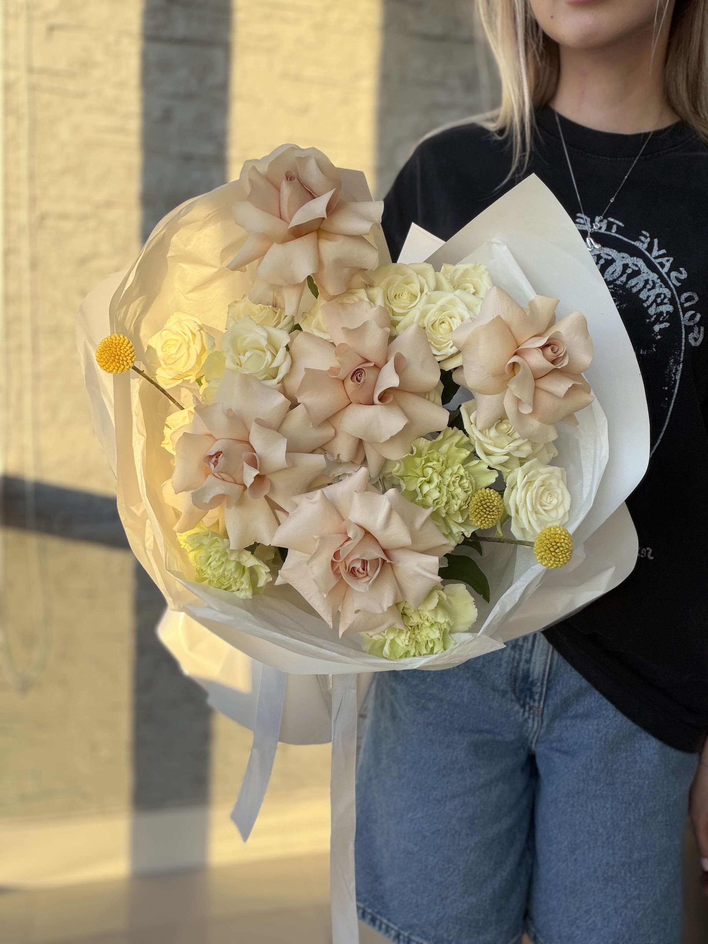 Person holding a bouquet of flowers with a blurred background