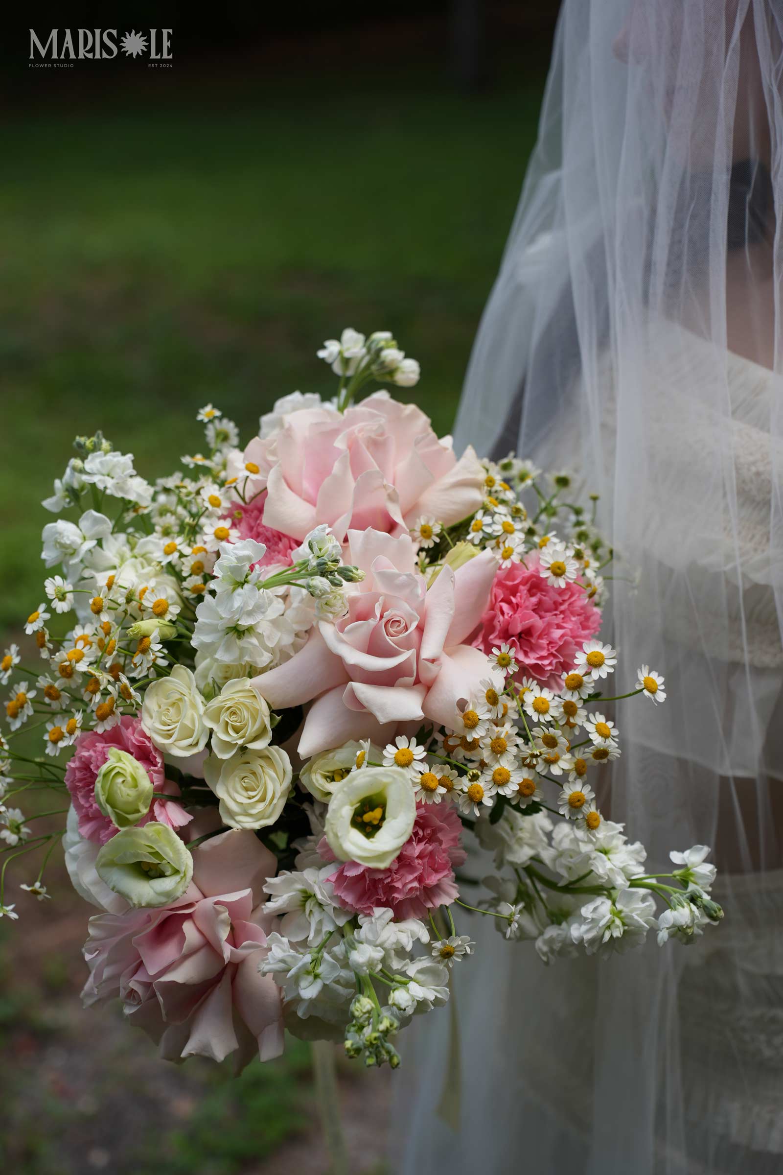 Close-up of pastel wedding flowers with pink roses and daisies
