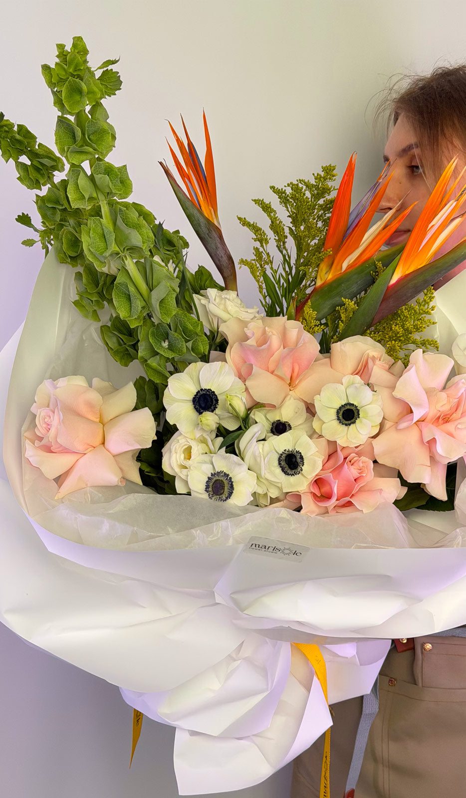 Person holding a bouquet of flowers with a white background