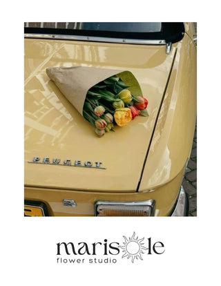 Greeting card with a bouquet of tulips on a vintage car, featuring Marisole Flower Studio logo.