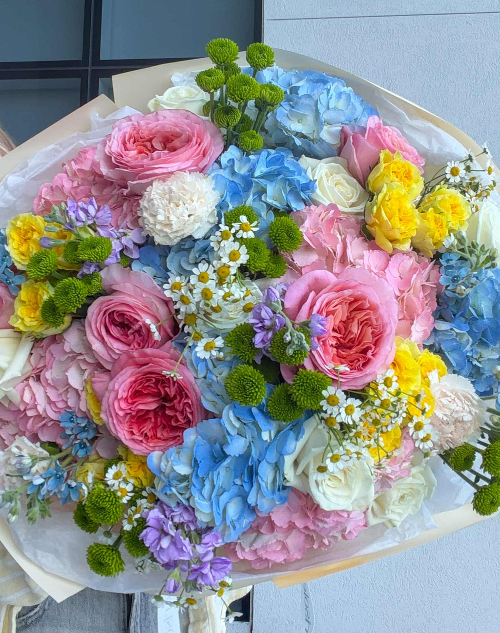 Close-up of Unicorn Bouquet with pastel garden roses, hydrangeas, spray roses, chamomile, chrysanthemums, and tweedia.