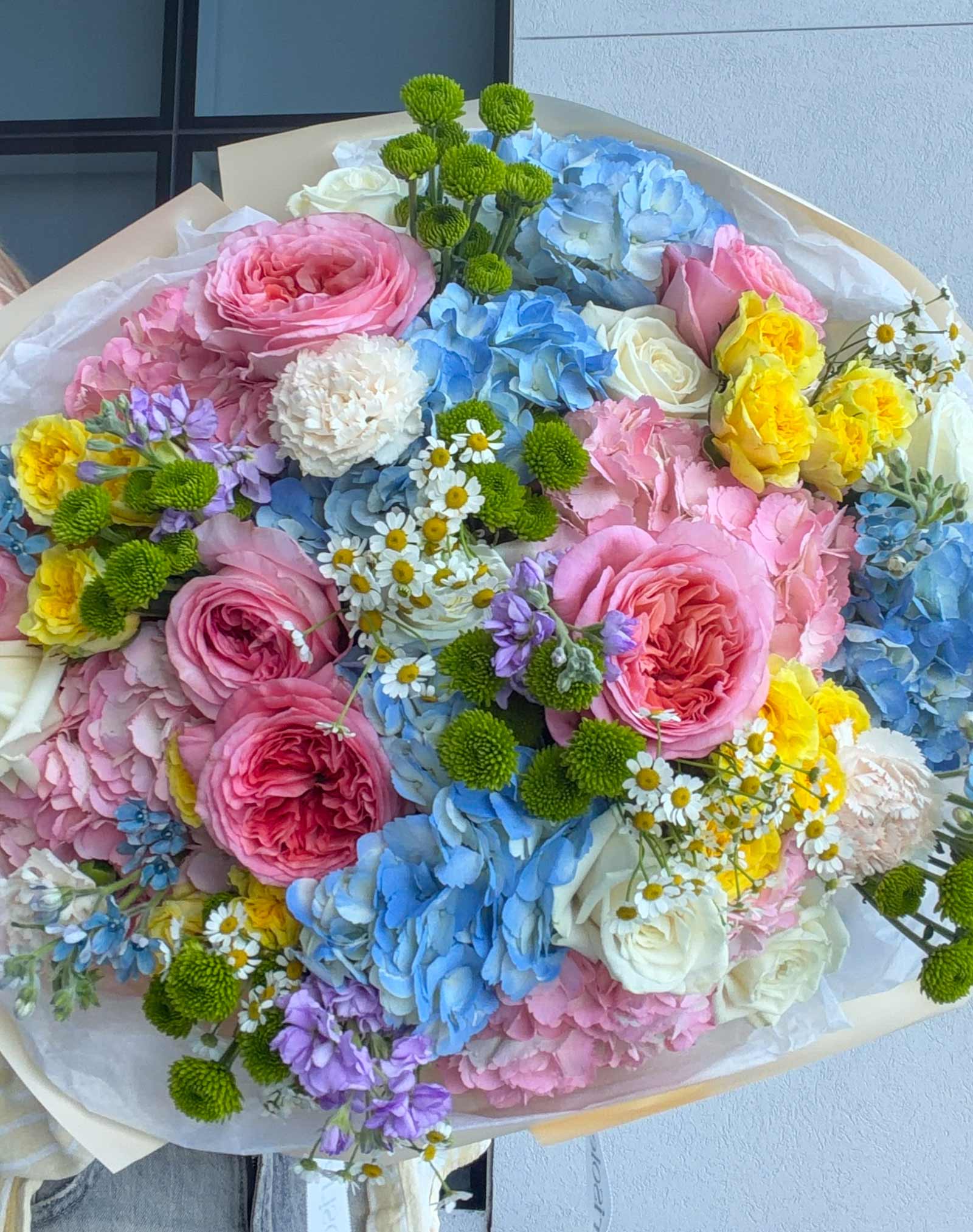 Close-up of Unicorn Bouquet with pastel garden roses, hydrangeas, spray roses, chamomile, chrysanthemums, and tweedia.