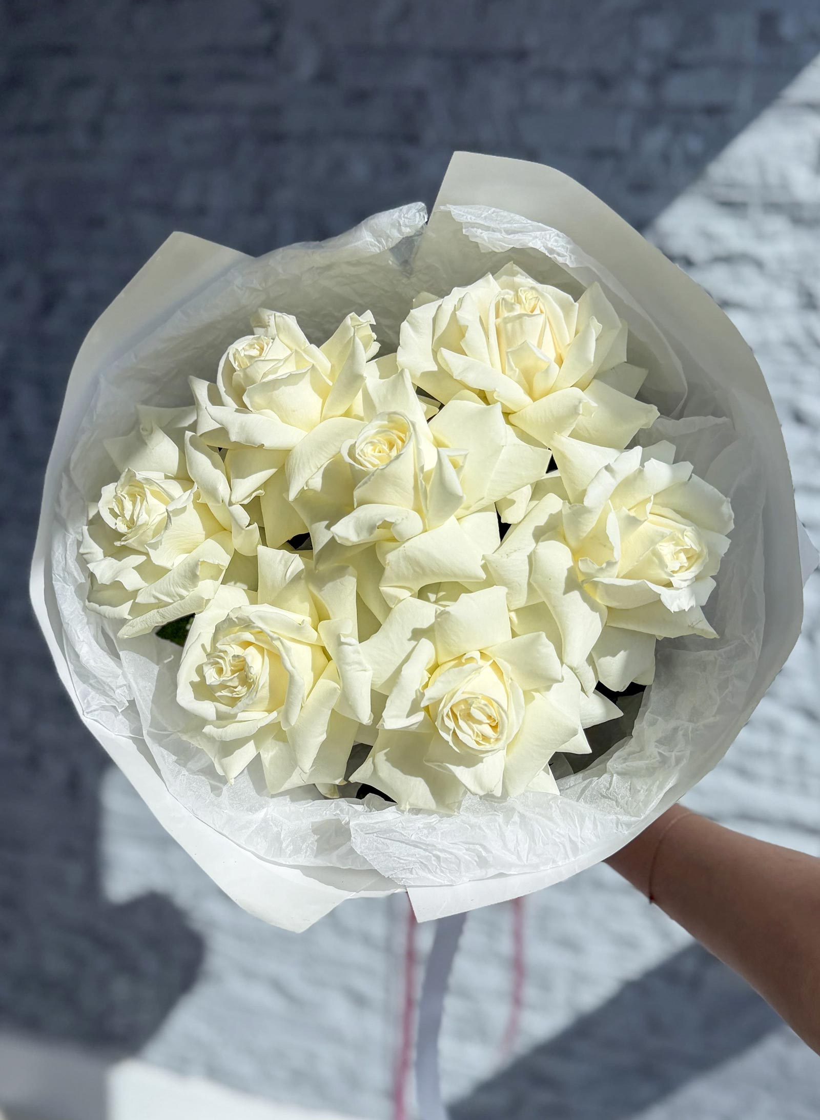 Close-up of a White French Roses bouquet featuring creamy white roses in elegant white wrapping.